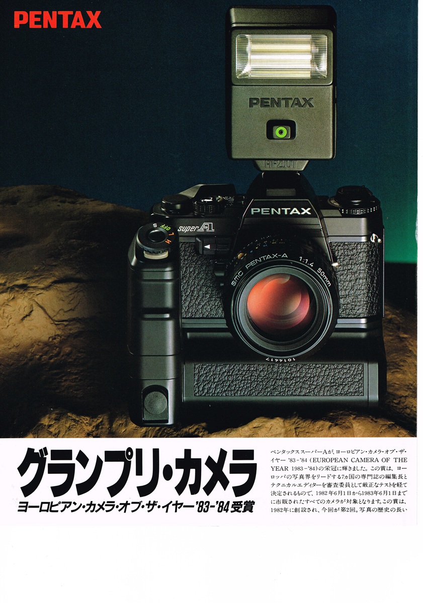 1983年のペンタックス・スーパーAの広告。モータードライブとストロボを装着した黒いボディが岩場のような場所に置かれた重厚な写真。
